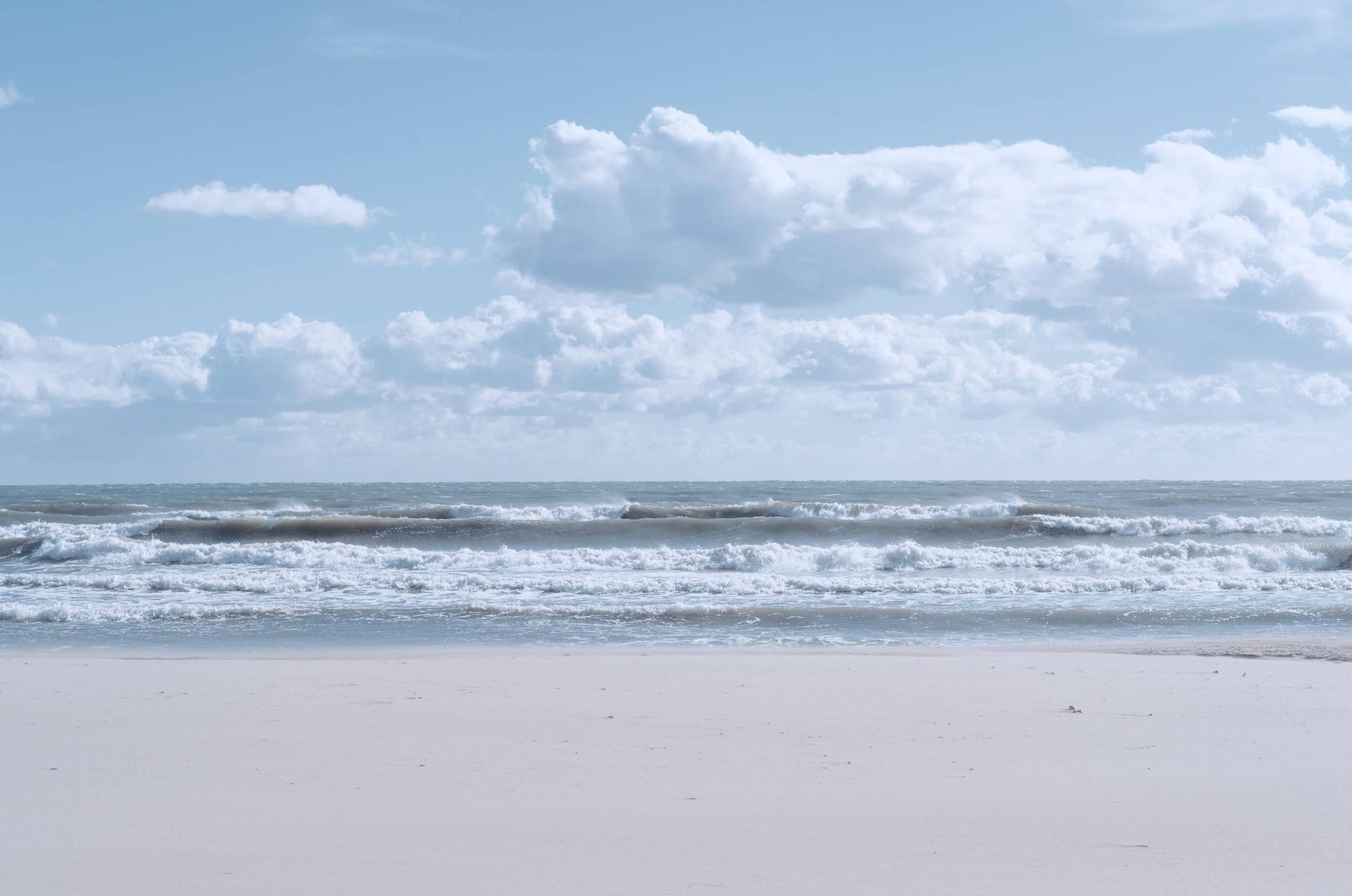 Gentle waves reaching a quiet sandy beach